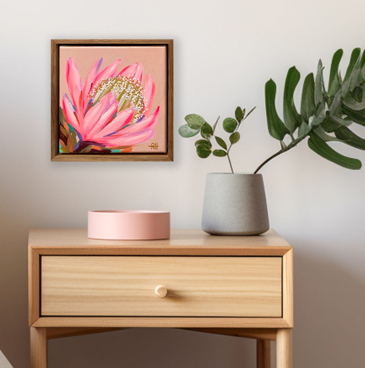 Glow Bloom – framed mini painting by Rachelle Holowko with a glowing pink protea on soft coral background.